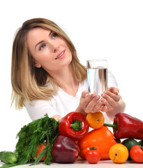 Woman with glass of pure drinking water and green vegetables and