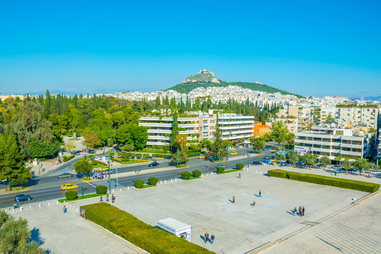 view of a small square in front of the Panathenaic stadium or kallimarmaro in Athens with lycabetus hill in background.