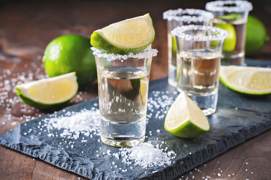 Tequila gold, Mexican, alcohol in shot glasses, lime and salt, toned image, selective focus