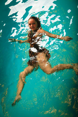 Woman floating relaxing in swimming pool water.