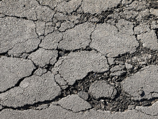 Old worn and cracked asphalt with cracks