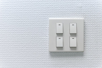 Four light switch on the white wall with copy space