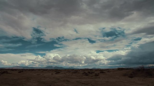 Time Lapse 2059: Time lapse storm clouds travel over a desert plain.