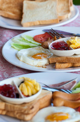 breakfast with fried eggs, sausages, cereal, toasts and coffee