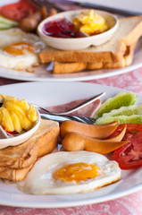 breakfast with fried eggs, sausages, cereal, toasts and coffee