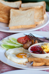 breakfast with fried eggs, sausages, cereal, toasts and coffee