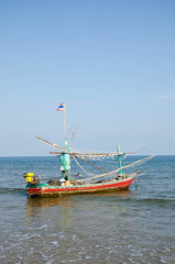 Obraz premium old wooden local fishing boat on on sea coast and beach with sum