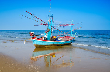 Fototapeta na wymiar old wooden local fishing boat on on sea coast and beach with sum