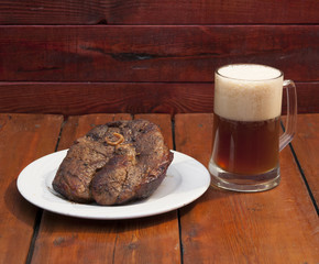 steak and beer on a wooden background