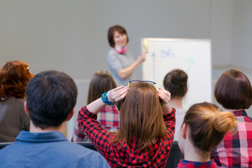 Group of Students Listening Lecturer staying at Flip Chart