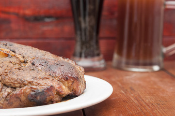 steak and beer on a wooden background