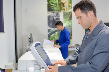 Man using control pad on printer