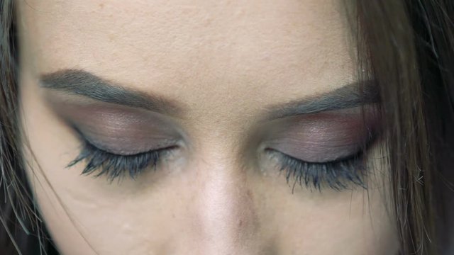 Close up of girl's eyes looking on a camera. Slowly