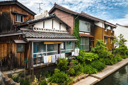Старинные японские жилые дома в провинциальном японском городе с маленьким зеленым садом возле дома