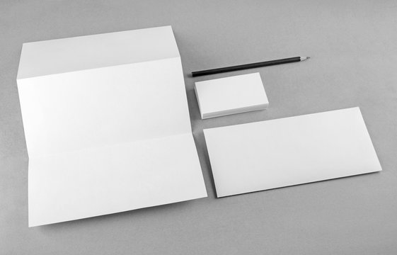 Photo of blank stationery set on gray background. Mock-up for branding identity. For design presentations and portfolios. Grayscale image.