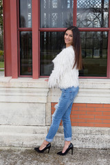 Urban girl posing in jeans close to a windows