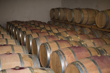 Wine barrels stacked in the old cellar of the winery.