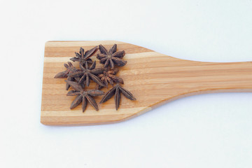Star Anise or bunga lawang on wooden spatula. Isolated background.