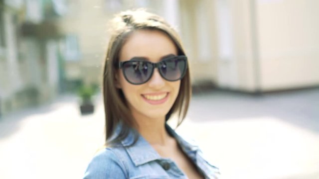 Girl with long hair turning to camera, smiling on the street. 4k