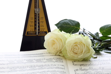 music notes, metronome and white roses