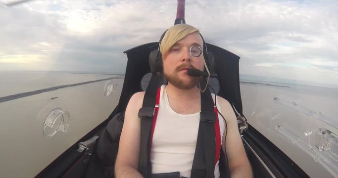Portrait of a stylish man in the cabin of the autogyro in the sky