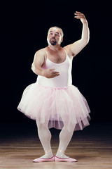 Fototapeta na wymiar funny fat classical dancer on black background