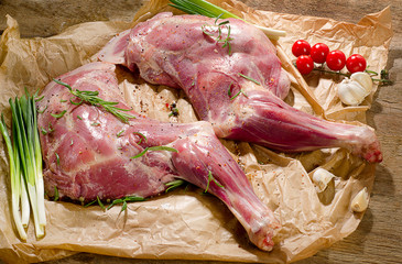 Raw lamb shanks ready for frying on a wooden board.