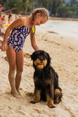 girl with two plaits and met in a swimsuit on the beach near the sea lovely dog