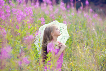 Young beautiful model girl wearing pink dress dream with lace umbrella in blossom flowers field