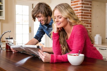 Cute couple reading the newspaper