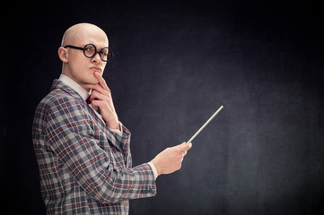 bald caucasian professor or teacher with bow and glasses tie point stick on blackboard with copy space
