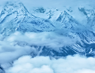 majestic winter landscape of Dombaj mountains covered peaks with clouds