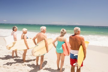 Senior friends holding surfboard