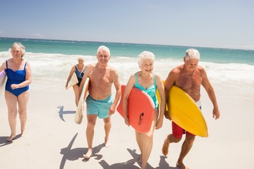 Senior friends holding surfboard