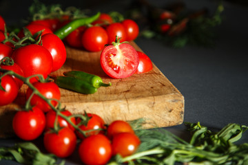 Tomatoes on wooden with green pappers and herbs