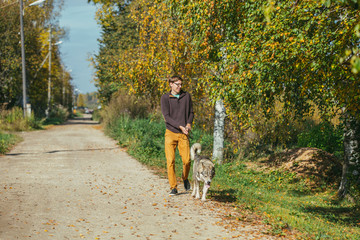 Man walking with a hunting dog - the West Siberian husky.