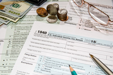 1040 tax form with dollar, glasses, mouse, calculator, notepad