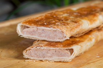 baking of unleavened dough with minced meat on a wooden board
