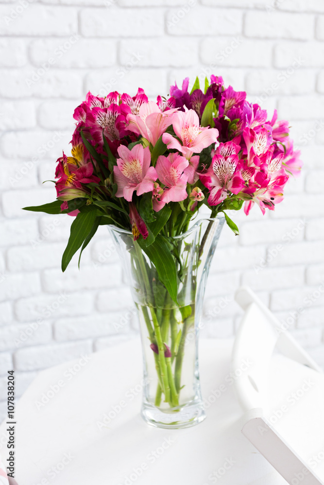 Wall mural Vase full of colorful flowers on table