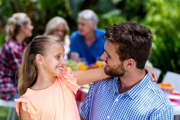 Father looking at daughter in yard 