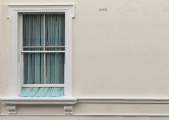 Apartment Window. With the coming of spring the windows stand a little bit open to let in a little bit of the spring air allowing the curtain a little bit of freedom.