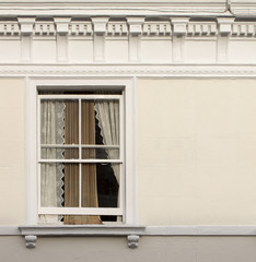 Apartment Window.  With the coming of spring, the windows stand a little bit open to let in a little bit of the spring air allowing the curtain a little bit of freedom.