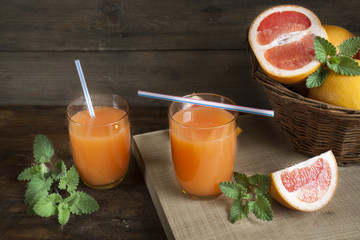 Natural and fresh grapefruit juice in glass with freshly harvested grapefruit