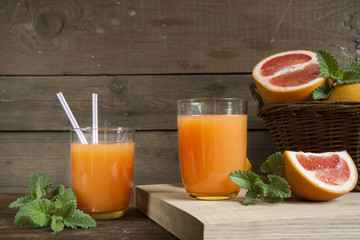 Natural and fresh grapefruit juice in glass with freshly harvested grapefruit