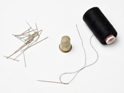 Hilo, aguja y dedal, utensilios de costura de sastre y modista