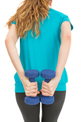 Rearview of woman doing strength training with dumbbells