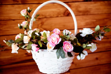 Fototapeta na wymiar Beautiful artificial roses in a wicker basket