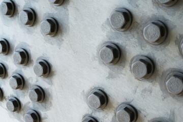 Gray metal surface with hexagonal bolt heads