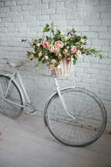 Fototapeta na wymiar Old bicycle and flowers close to the white brick wall