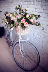 Naklejka na ściany i meble Old bicycle and flowers close to the white brick wall